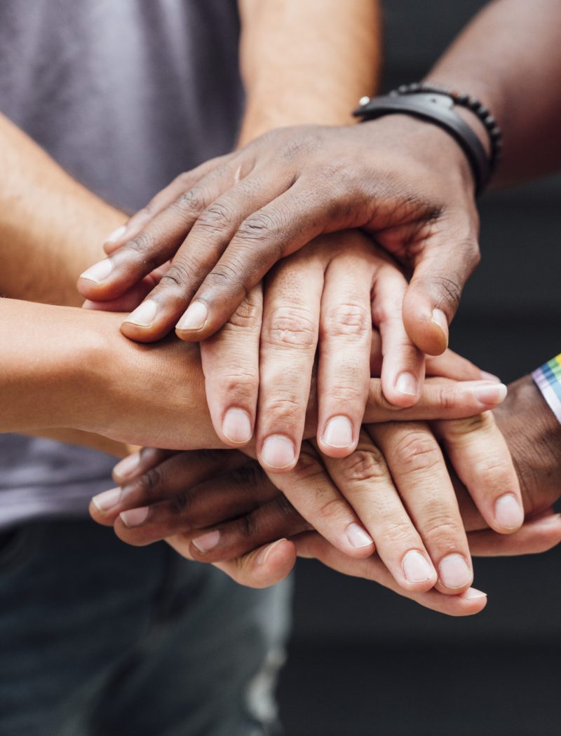 Different people putting hands in stack Different people putting hands in stack